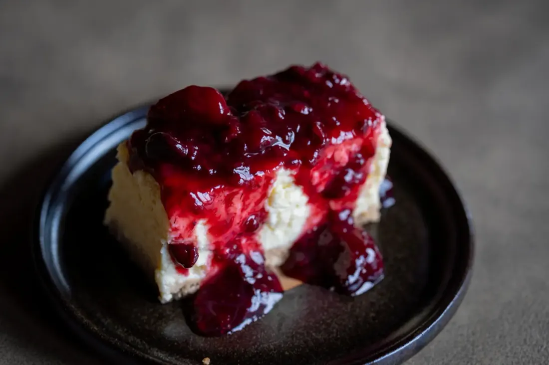 Porción de cheesecake con frutos rojos